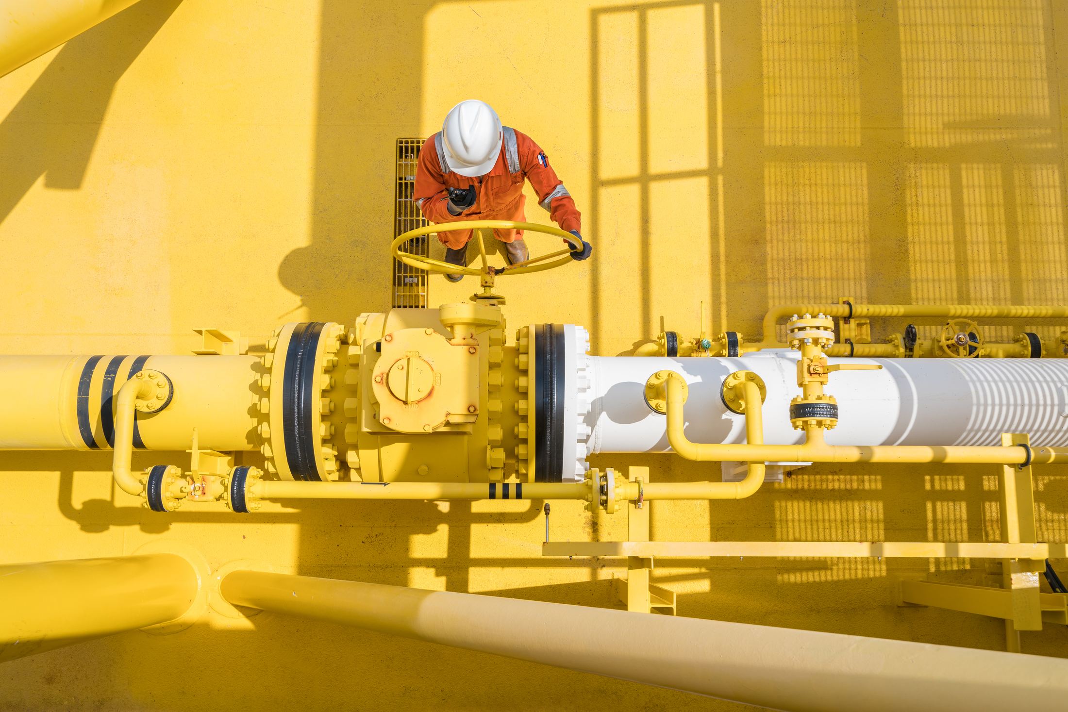 Production operator communicating by radio while operating a valve at a SAGD facility